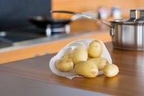 Raw potatoes on table — Stock Photo