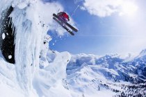 Esquiador saltando pendiente nevada - foto de stock