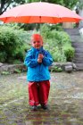 Kleinkind hält Regenschirm im Hinterhof — Stockfoto