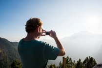 Veduta posteriore dell'uomo che fotografa le montagne, Passo Maniva, Italia — Foto stock