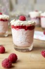 Glass of pudding with raspberries and cream on table — Stock Photo
