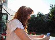Женщина использует мобильный телефон на открытом воздухе — стоковое фото