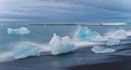Льодовики миють на пляжі під хмарним небом — стокове фото