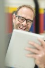 Uomo d'affari in occhiali da vista utilizzando tablet digitale — Foto stock