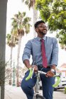 Молодий чоловік їде на велосипеді, посміхаючись — стокове фото
