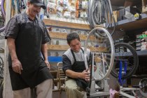 Mecânica trabalhando na loja de bicicletas — Fotografia de Stock