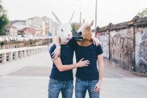 Портрет двух мужчин в масках кролика и лошади на городском мосту — стоковое фото