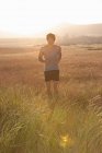 Uomo che fa jogging nell'erba alta — Foto stock