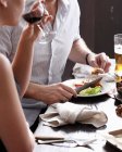 Two people eating and drinking in restaurant, mid section — Stock Photo