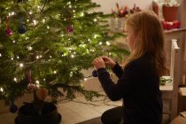 Young girl decorating christmas tree — Stock Photo