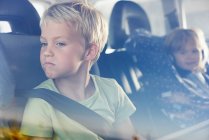 Двоє дітей сиділи в задній частині машини — стокове фото