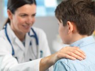 Arzt tröstet kleinen Jungen in Klinik — Stockfoto