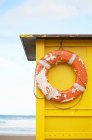 Life preserver hanging from hut on beach — Stock Photo