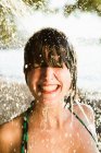 Frau steht in Dusche am Strand — Stockfoto