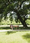 Старшая женщина сидит на скамейке в парке — стоковое фото