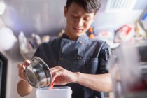 Азіатський шеф-кухар на комерційній кухні готує їжу — стокове фото