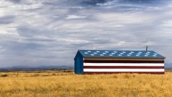 Barn in dry field painted with stars and stripes — Stock Photo