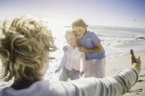 Père ouvrant les bras aux fils sur la plage — Photo de stock