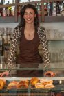 Female shopkeeper at counter — Stock Photo