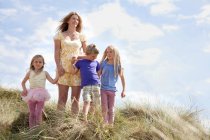 Мать с тремя детьми на дюнах, Уэльс, Великобритания — стоковое фото