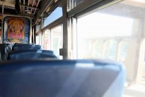 Empty seats and buddhist poster inside of bus — Stock Photo