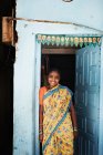 Усміхнена жінка стоїть у дверному отворі — стокове фото