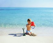 Мальчик играет с песком — стоковое фото