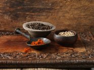 Black and white peppercorns and paprika — Stock Photo