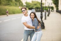 Young couple laughing on city street, London, UK — Stock Photo