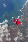 Vista aérea de la mujer en traje de ala volando por encima de Honolulu, Hawaii - foto de stock