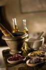 Herbs and oils on table with mixing bowls — Stock Photo