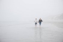 Couple courant sur la plage — Photo de stock