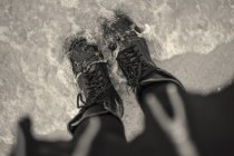 Vista de ángulo alto de la mujer joven en botas atadas en el mar - foto de stock