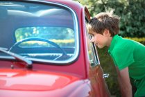 Menino olhando através da janela do automóvel vintage — Fotografia de Stock