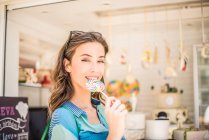 Portrait of woman with lollipop from sweet stall, Dubai, United Arab Emirates — Stock Photo