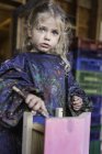 Маленька дівчинка в захисному одязі малює дерев'яний будинок — стокове фото
