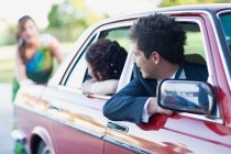 Teenage girl in gown pushing car, selective focus — Stock Photo