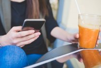 Schnappschuss von junger Frau mit Smartphone in Bürgersteig-Café — Stockfoto