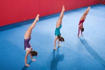 Gymnastes dans une rangée de faire des stands — Photo de stock