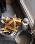 Hand cut chips and salt shaker — Stock Photo