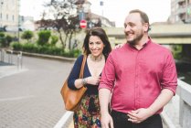 Couple heureux marchant sur le trottoir ensemble — Photo de stock