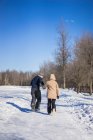 Молодая пара, идущая вместе зимой в лесу, Монреаль, Квебек, Канада — стоковое фото