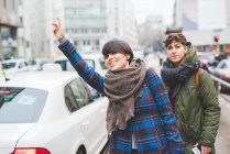 Two sisters hailing taxi — Stock Photo