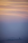 Toits en silhouette émergeant des nuages bas au coucher du soleil, Langhe, Piémont. Italie — Photo de stock