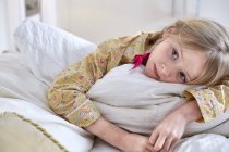 Menina em pijama dia-sonhando na cama — Fotografia de Stock