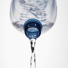 Water pouring out of plastic bottle, close up shot — Stock Photo