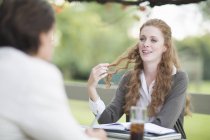 Over the shoulder view of businessman and female colleague having informal meeting in garden — Stock Photo