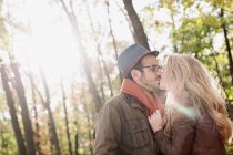 Улыбающаяся пара целуется в лесу — стоковое фото