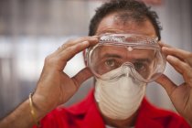Carpenter putting on protective glasses — Stock Photo