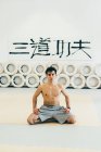 Mann kniet auf Gymnastikmatte und blickt in Kamera — Stockfoto